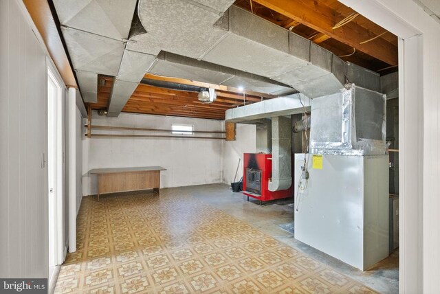 unfinished basement featuring tile patterned floors and heating unit