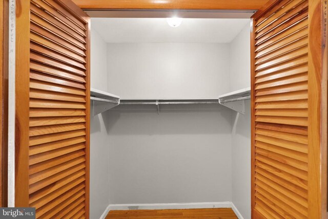 walk in closet with wood finished floors