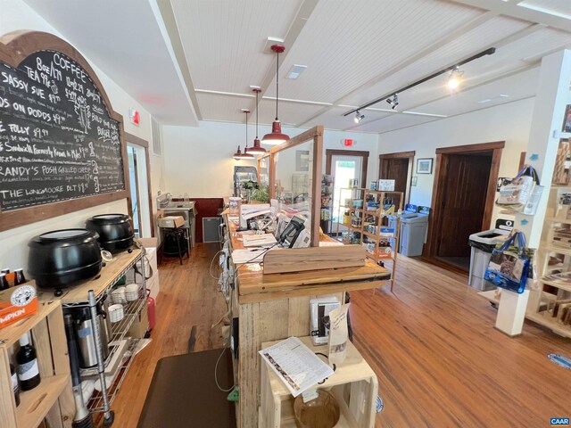 dining space with hardwood / wood-style flooring and rail lighting