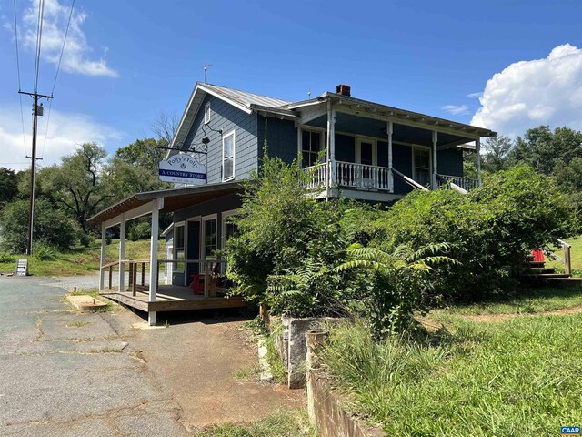 view of side of home featuring covered porch