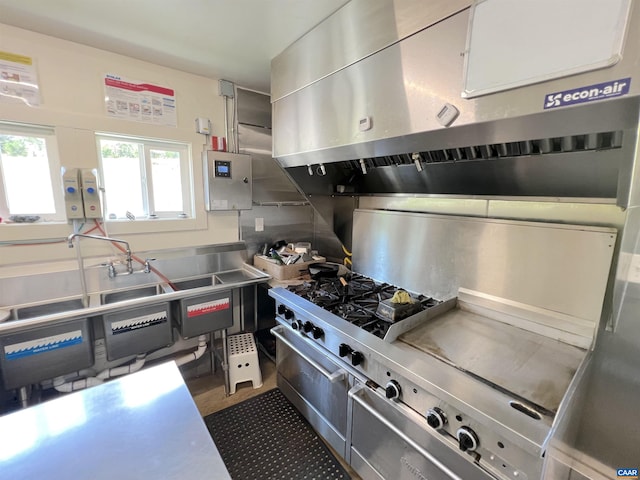 kitchen with white cabinetry, extractor fan, and stainless steel counters