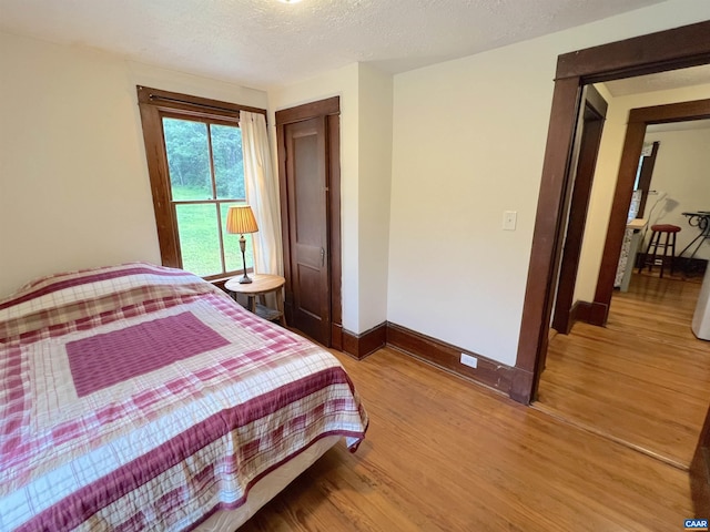 bedroom with hardwood / wood-style flooring and a textured ceiling