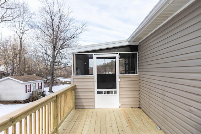 wooden deck featuring an outbuilding and a sunroom