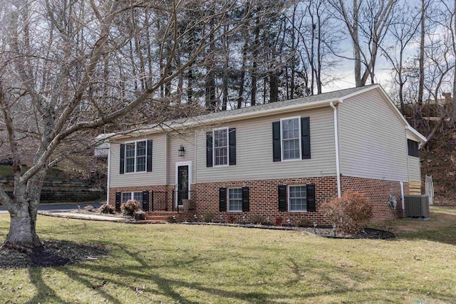 split foyer home featuring central AC unit and a front lawn