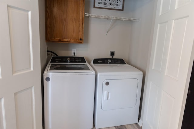 clothes washing area with cabinet space and washing machine and clothes dryer