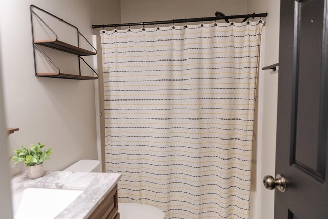 bathroom featuring vanity, curtained shower, and toilet