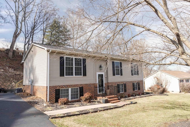 split foyer home featuring a front yard and brick siding