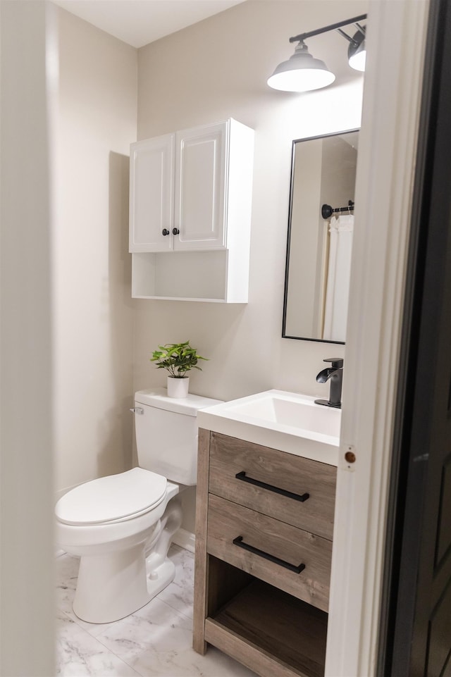 bathroom featuring marble finish floor, baseboards, vanity, and toilet