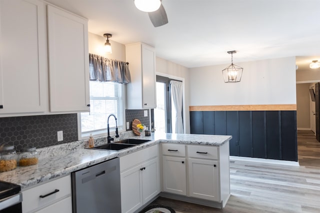 kitchen featuring dishwasher, sink, white cabinets, hanging light fixtures, and kitchen peninsula