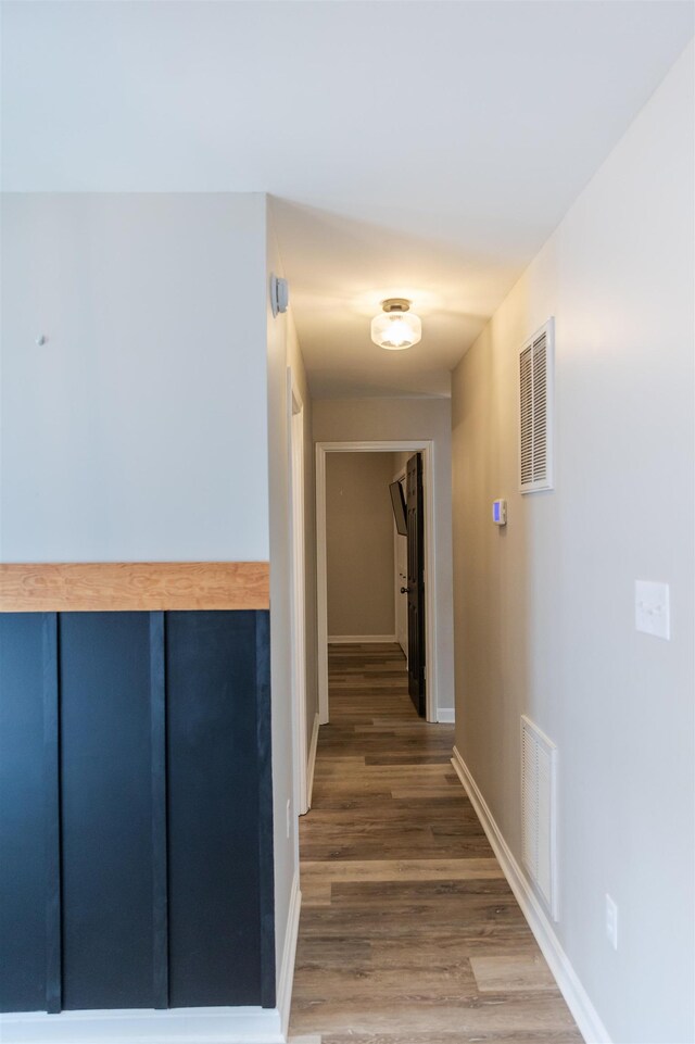 unfurnished bedroom with a barn door, dark wood-type flooring, connected bathroom, and ceiling fan