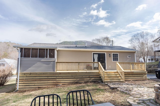 back of house with a wooden deck and a sunroom