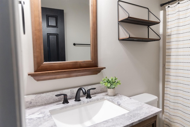 bathroom featuring toilet, a shower with curtain, and vanity