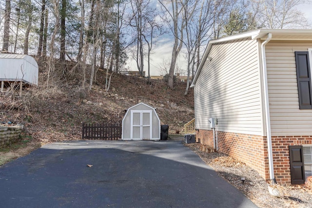 exterior space with an outbuilding, a storage unit, and brick siding