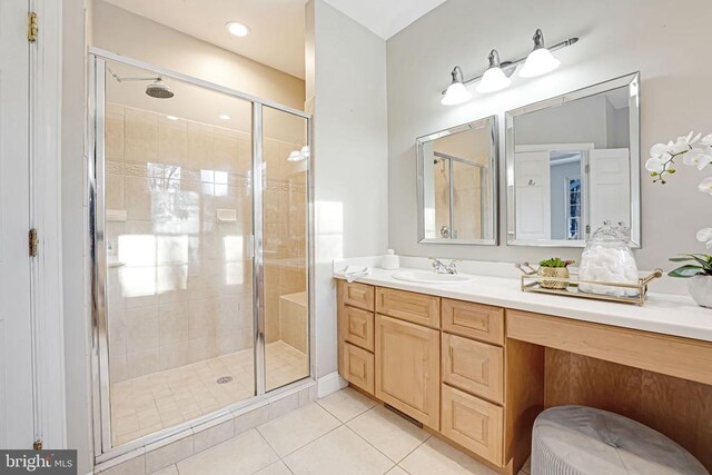 bathroom with walk in shower, vanity, and tile patterned flooring