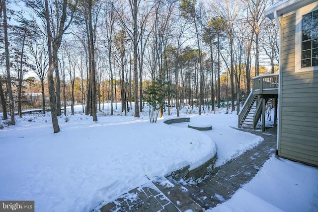 yard covered in snow with a wooden deck