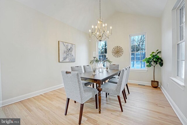 dining space featuring crown molding, lofted ceiling, a notable chandelier, and light wood-type flooring