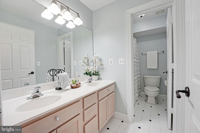 bathroom with tile patterned floors, vanity, toilet, and a chandelier