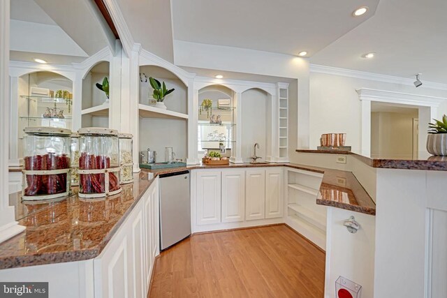 kitchen featuring crown molding, dark stone countertops, white cabinets, kitchen peninsula, and light wood-type flooring