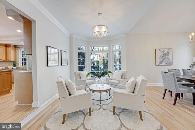 living room featuring an inviting chandelier, crown molding, and light hardwood / wood-style flooring