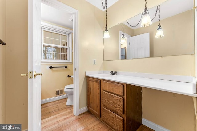 bathroom with hardwood / wood-style flooring, vanity, and toilet