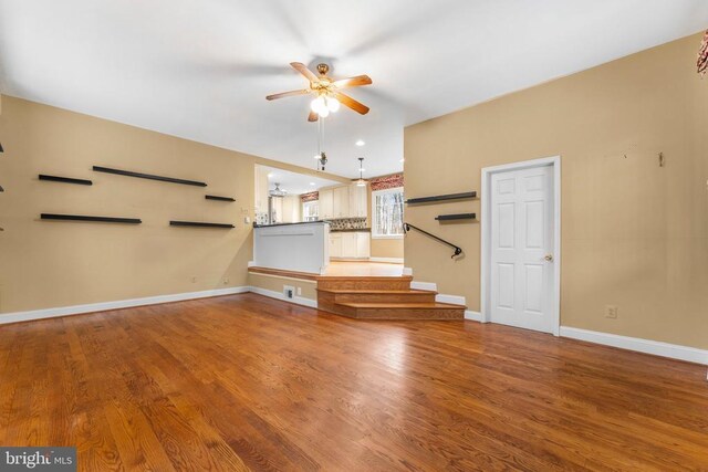 unfurnished living room with hardwood / wood-style flooring and ceiling fan