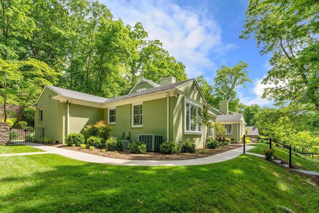 view of home's exterior with a lawn and central air condition unit