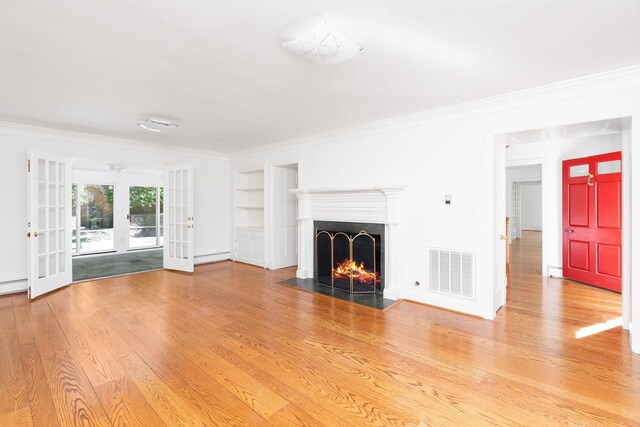 unfurnished living room with crown molding, hardwood / wood-style flooring, french doors, and baseboard heating