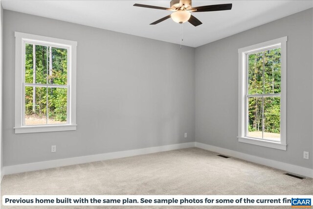 spare room featuring light colored carpet and ceiling fan