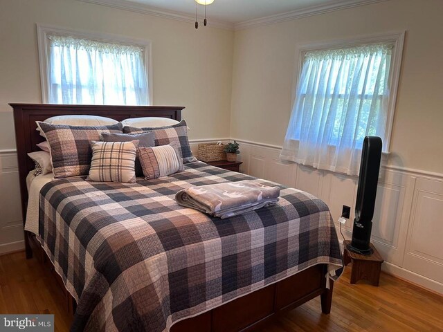 bedroom with hardwood / wood-style flooring and ornamental molding