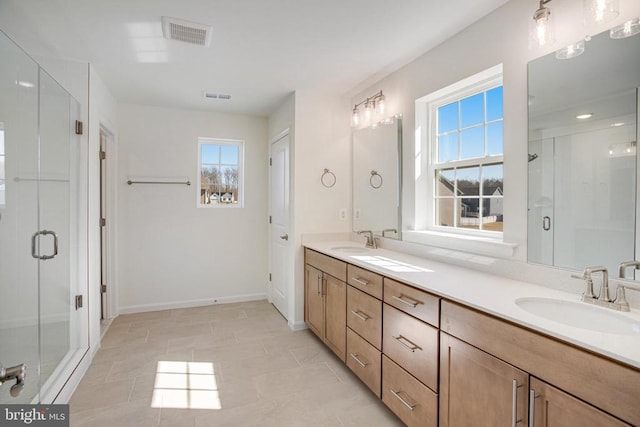 bathroom with visible vents, a sink, a shower stall, and double vanity