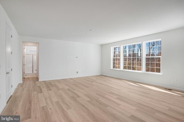 unfurnished room with light wood finished floors and baseboards