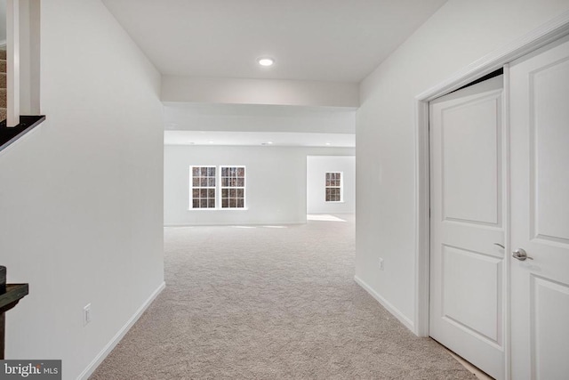 hall with baseboards, recessed lighting, stairs, and light colored carpet