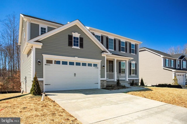 traditional-style house featuring a garage, covered porch, concrete driveway, and a front yard