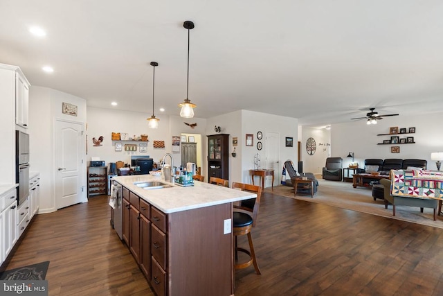 kitchen with white cabinetry, sink, pendant lighting, and dark hardwood / wood-style flooring