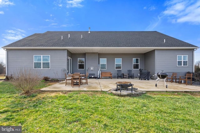 rear view of property with a fire pit, a lawn, and a patio