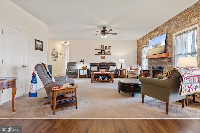 living room with a fireplace, light hardwood / wood-style flooring, and ceiling fan