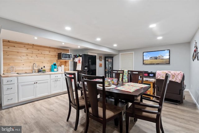 dining room featuring sink and light wood-type flooring