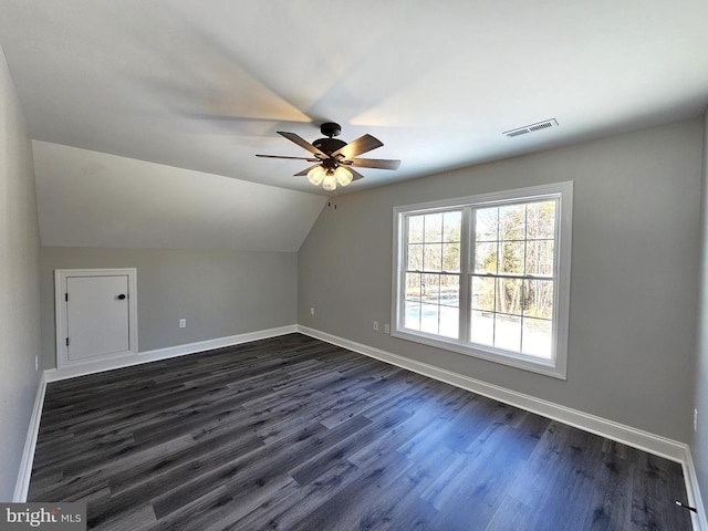 bonus room with baseboards, visible vents, dark wood finished floors, ceiling fan, and vaulted ceiling