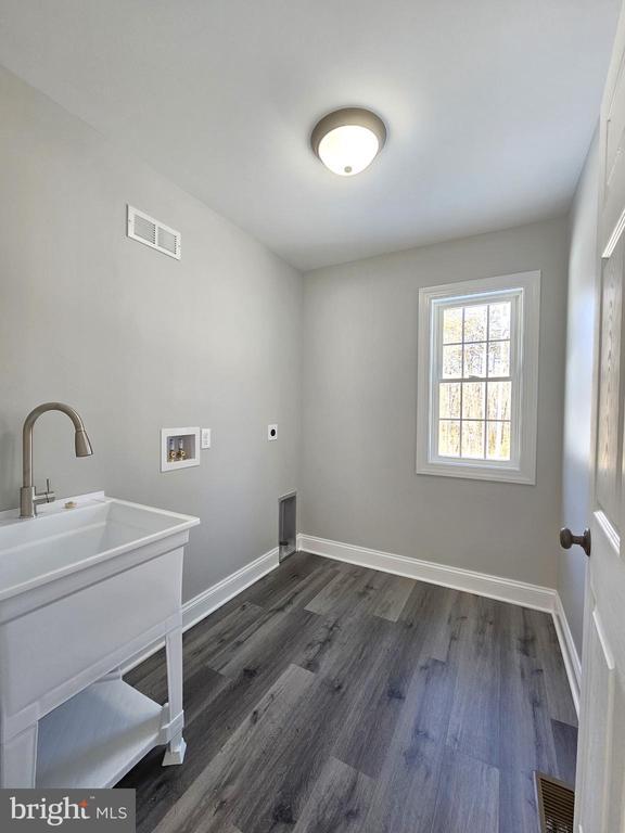 clothes washing area with hookup for a washing machine, laundry area, visible vents, and electric dryer hookup