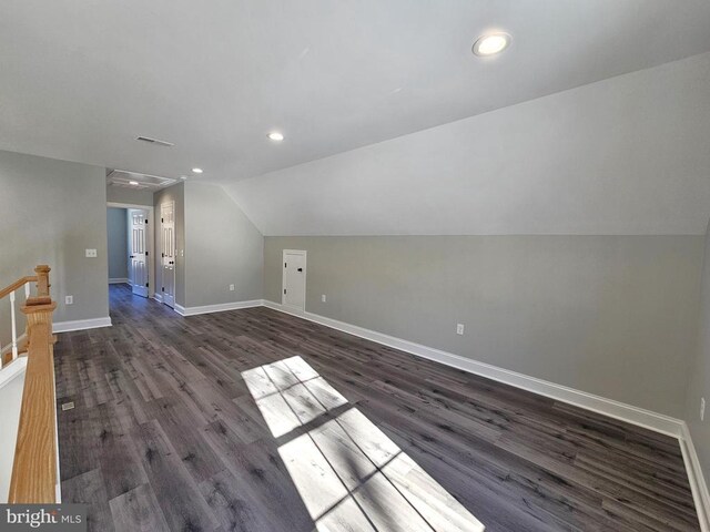 bonus room featuring baseboards, vaulted ceiling, and dark wood-type flooring