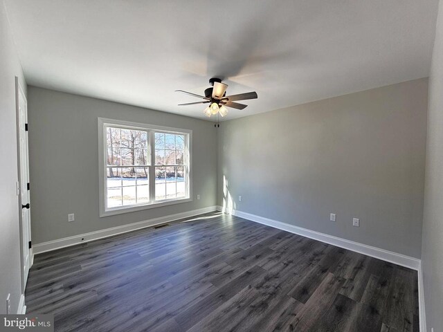 unfurnished room with a ceiling fan, visible vents, baseboards, and dark wood-style flooring