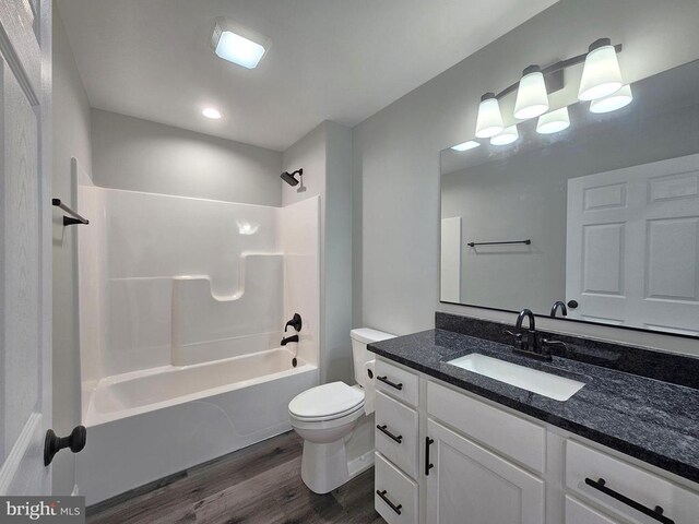 full bathroom with vanity, bathing tub / shower combination, toilet, and wood finished floors