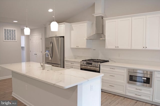 kitchen featuring stainless steel appliances, white cabinetry, light wood-style floors, and wall chimney exhaust hood