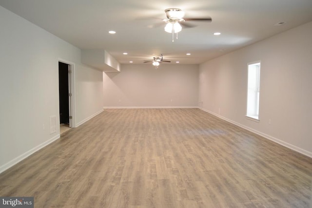 empty room featuring baseboards, wood finished floors, and recessed lighting