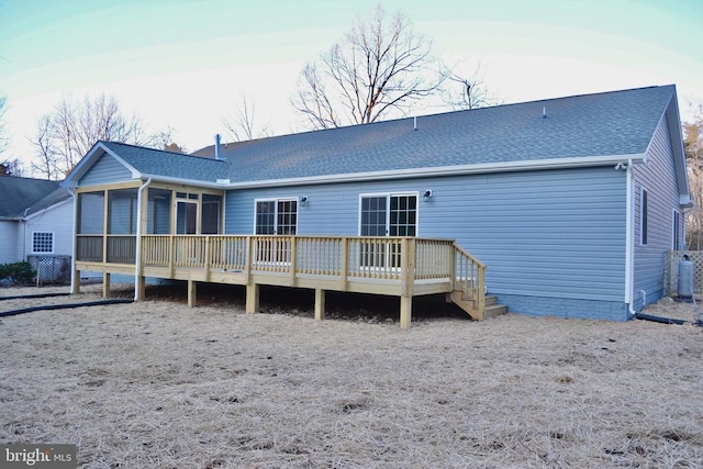 back of property featuring a shingled roof, a sunroom, and a deck