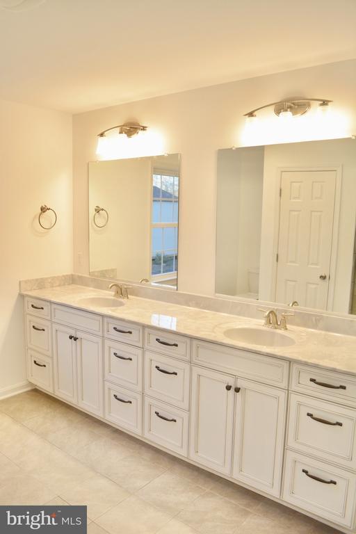 bathroom featuring double vanity, a sink, and tile patterned floors