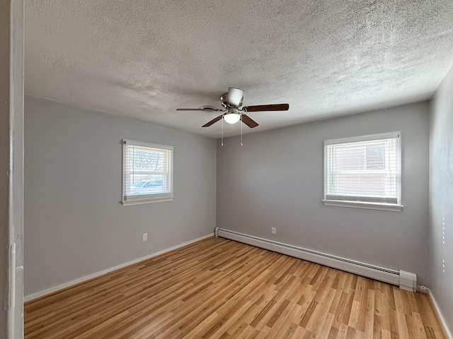 unfurnished room featuring a ceiling fan, light wood-style floors, baseboards, and baseboard heating