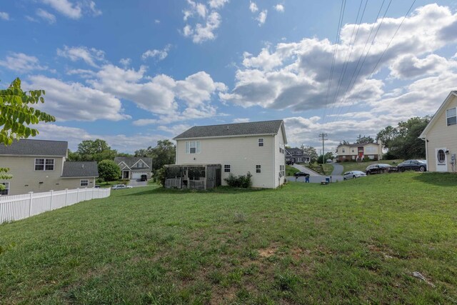 rear view of house featuring a lawn