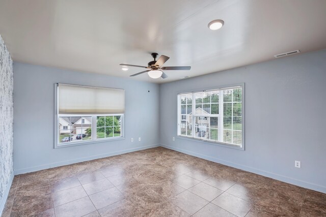 spare room featuring light tile patterned flooring, plenty of natural light, and ceiling fan