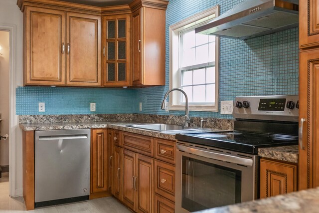 kitchen featuring ventilation hood, tasteful backsplash, sink, dark stone countertops, and stainless steel appliances